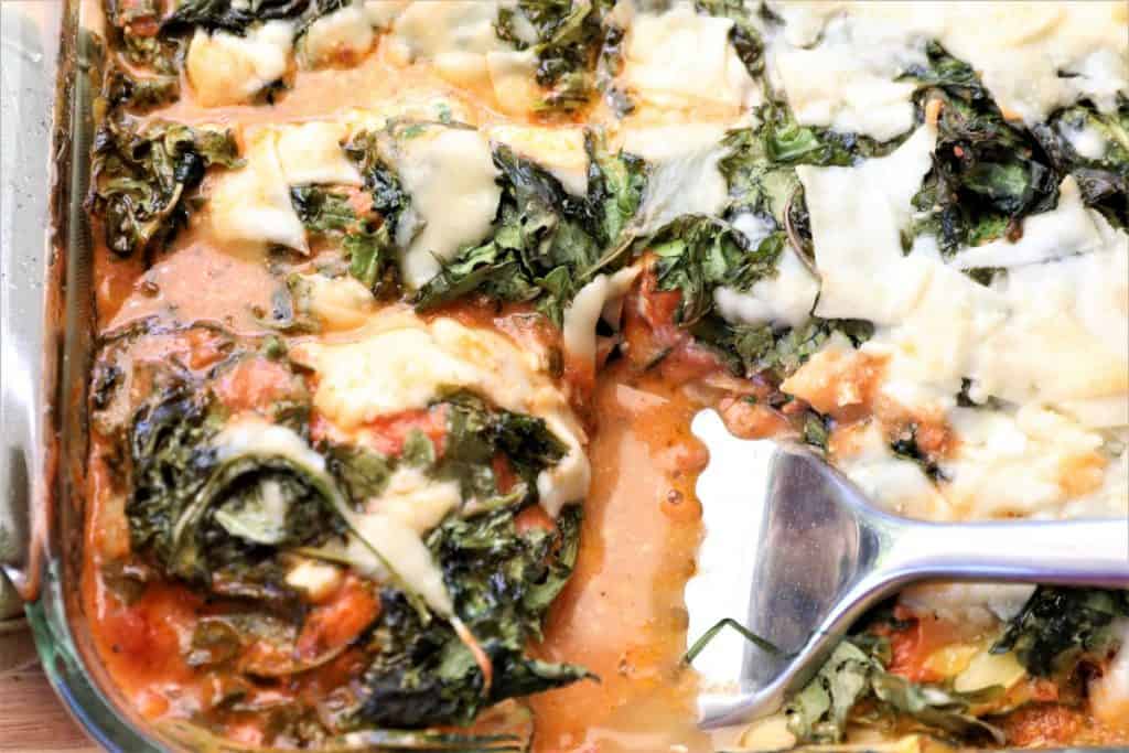 serving zucchini kale lasagna with a slotted spatula