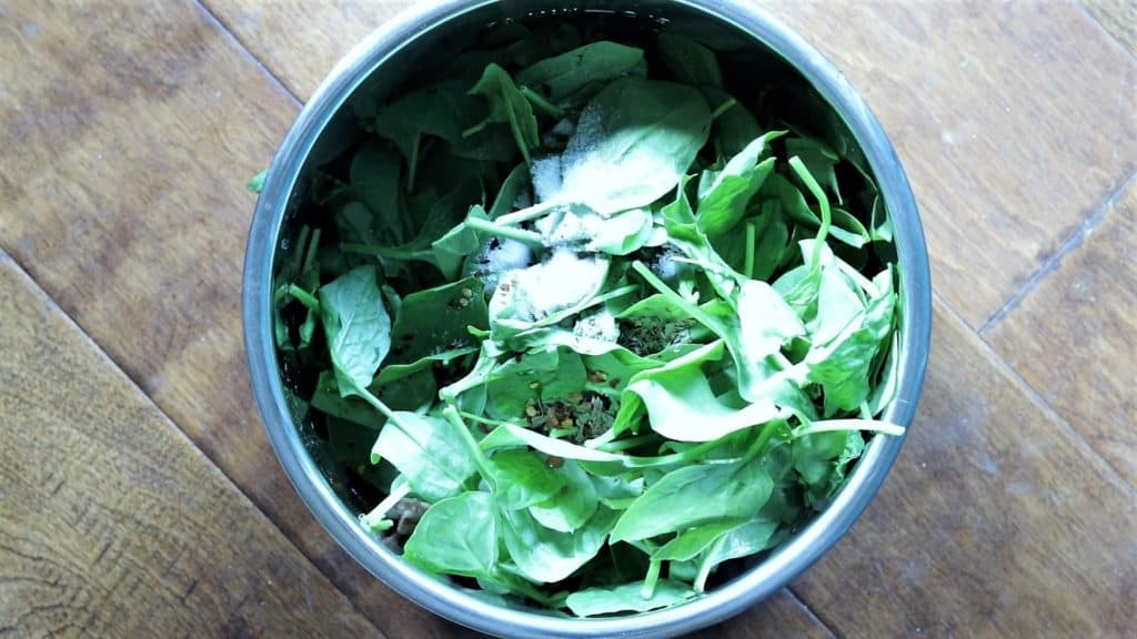 spinach and spices being added to the instant pot