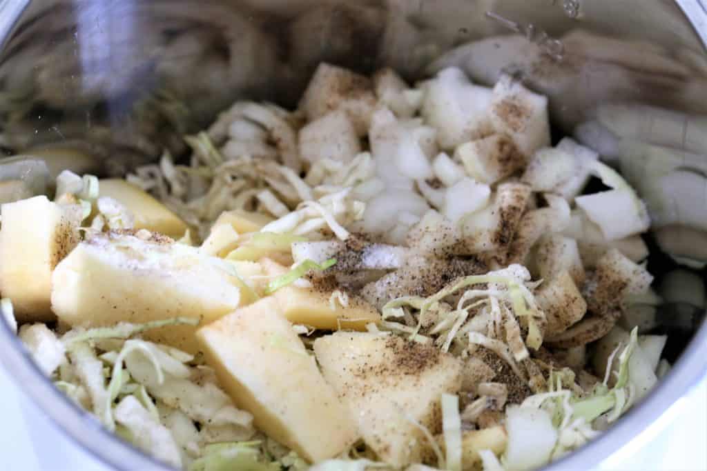potatoes, cabbage, onions, and seasonings in the inner pot of the Instant Pot