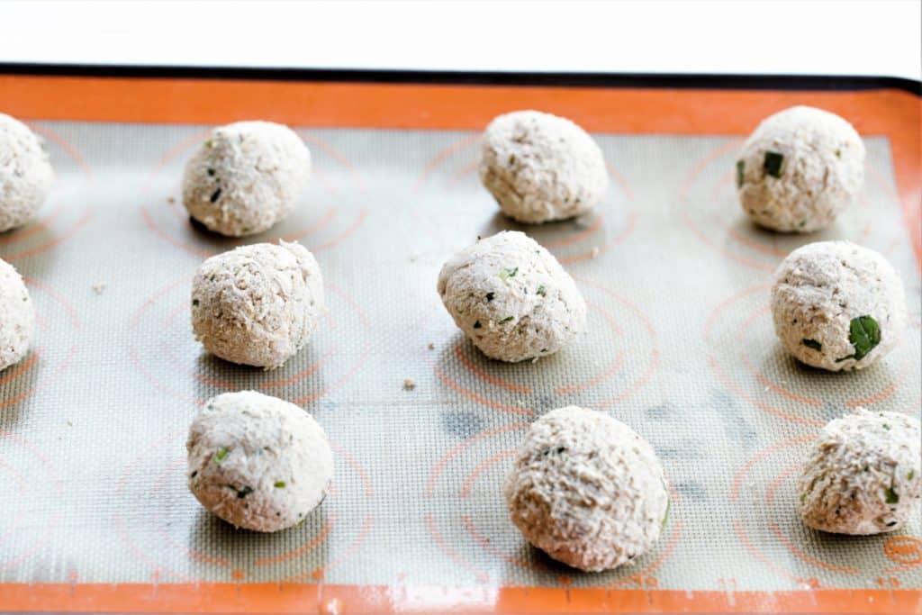 rolled vegan meatballs on a silicone mat before baking 