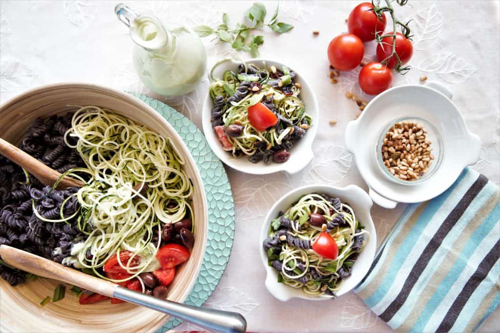 large bowl of black bean pasta salad with serving plates