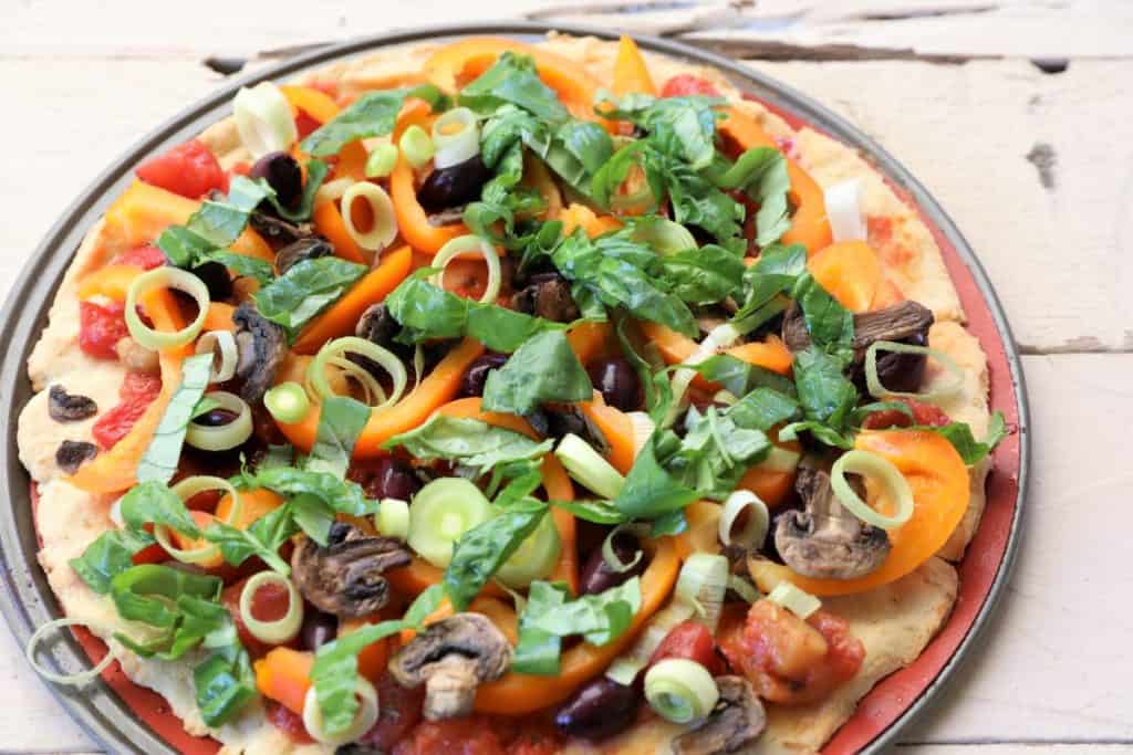 cauliflower quinoa pizza with mushrooms, fresh basil, and bell peppers