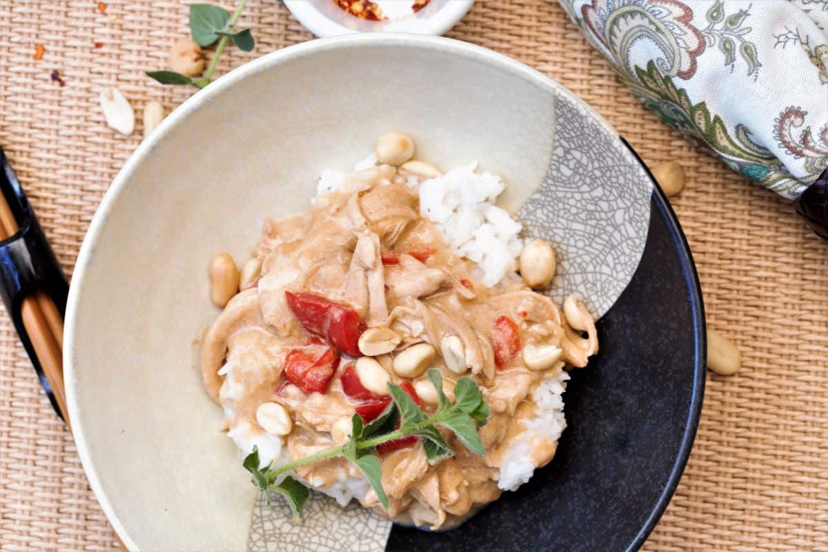 Bowl of Spicy Peanut Chicken with herbs