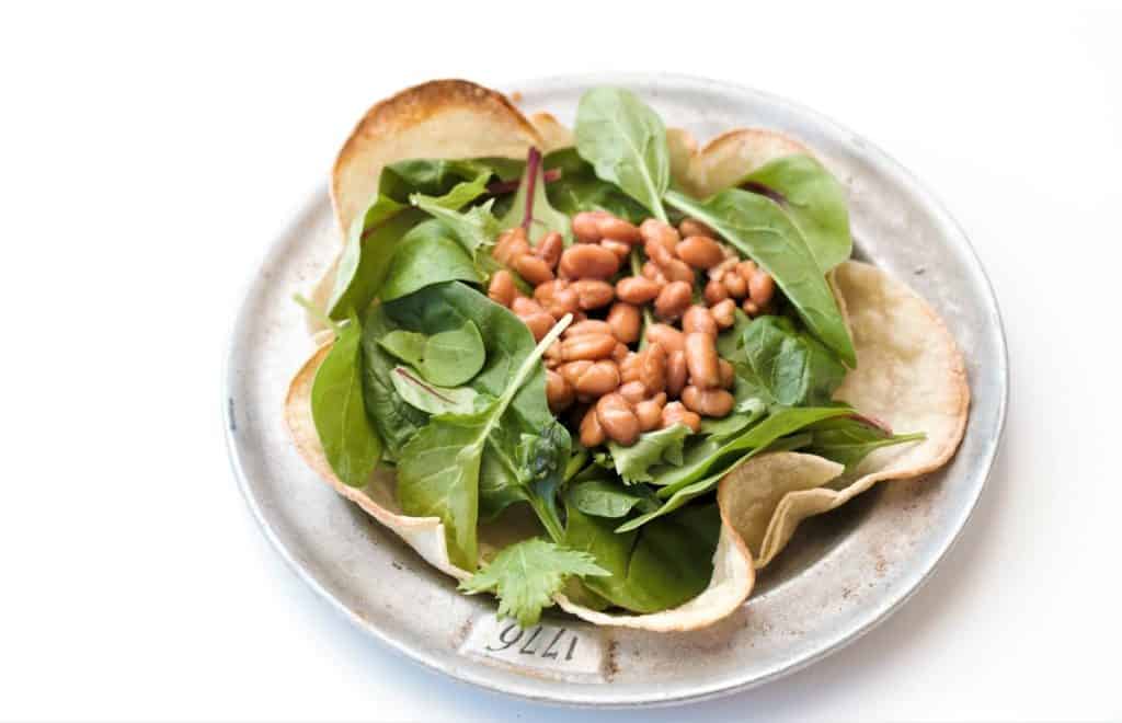 Add greens, pinto beans to taco shell