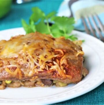 vegetarian enchilada casserole on plate with napkin and cilantro